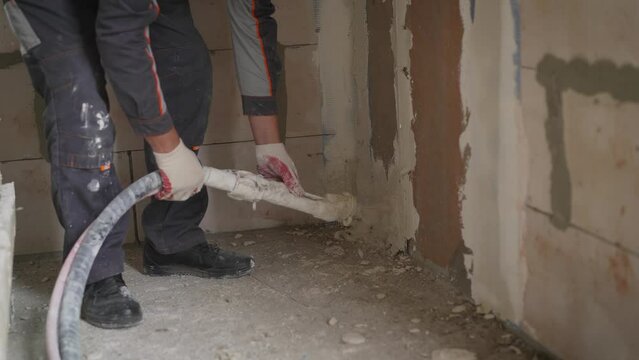 The plaster is applied with a hose. Automatic plastering process, plastering machine. Application of plaster in a mechanized way.