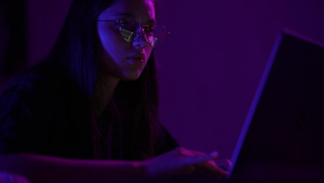 Attractive young woman working in home at night.