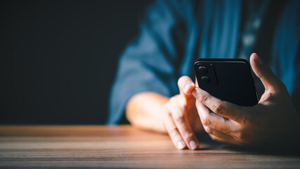 Closeup image of a man holding and using mobile phone or smartphone.