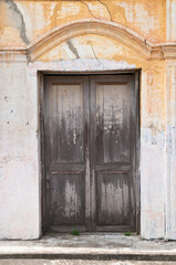 Fototapeta na wymiar Old dark brown wooden closed door of a traditional house in Asia