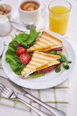 Tasty breakfast - sandwiches with fried eggs and bacon, coffe and glass of orange juice