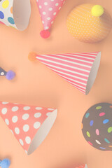 Colorful birthday caps on orange background. Top view.