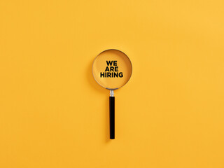 Magnifying glass or magnifier with the announcement we are hiring.