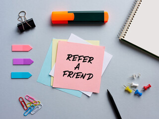 The note refer a friend written on a notepaper on office desktop.