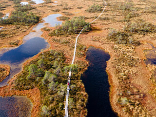 Wooden hiking trails in swamps or bog in Estonian nature reserve Kakerdaja. Drone aerial view