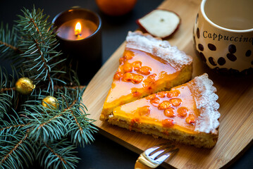 Naklejka na ściany i meble Slices of sea buckthorn pie on festively decorated table. Sugar, gluten and lactose free and vegan.