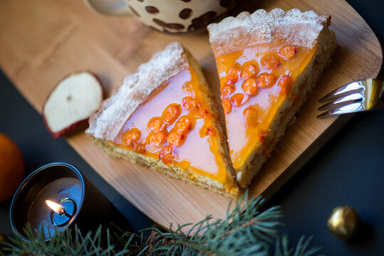 Slices of sea buckthorn pie on festively decorated table. Sugar, gluten and lactose free and vegan.