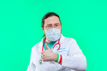 Doctor in a white coat and mask shows thumbs up. The doctor shows a gesture of approval. Bracelet in the colors of the flag of Italy.