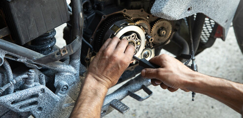Mechanic repairing engine of motorcycle. Concept of motorcycle maintenance