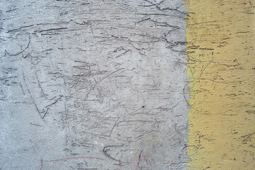Old concrete wall in gray and yellow, scratched cement wall, background texture