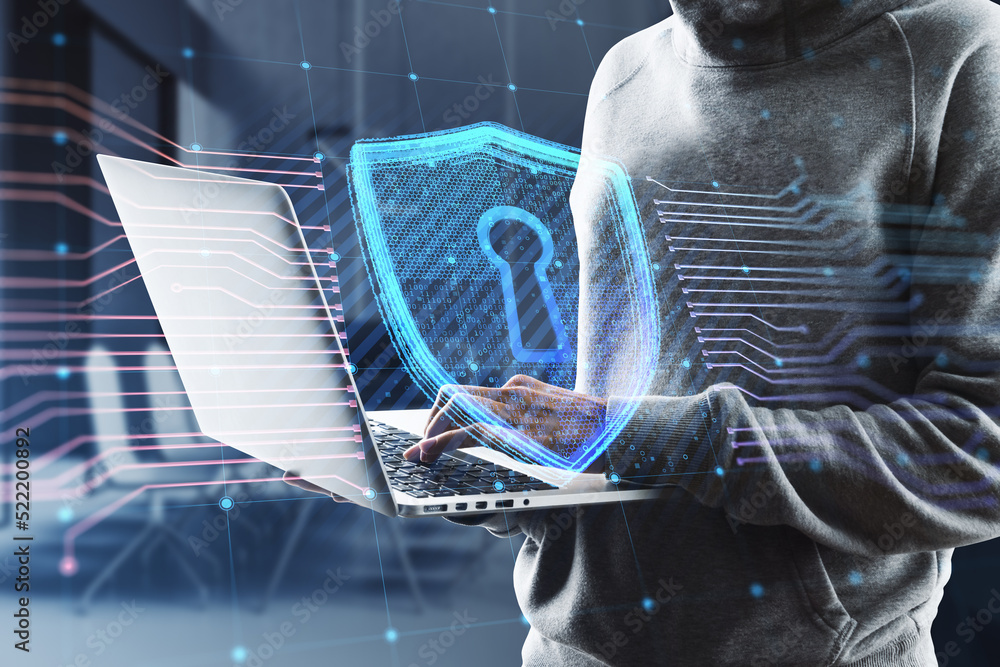 Poster Close up of hacker hands using laptop with creative glowing shield circuit security hologram on blurry office interior background. Safety and web protection concept. Double exposure.