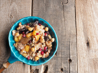 Tasty Noah s ark pudding in a creamic bowl on a rustic wooden table, traditional turkish food