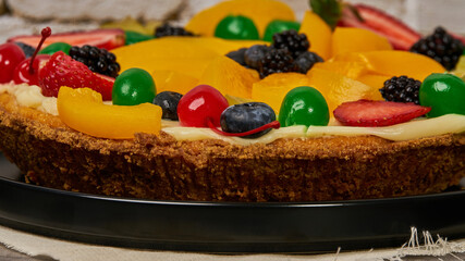 fruit cake with strawberries, blueberries, cherries and peaches side view