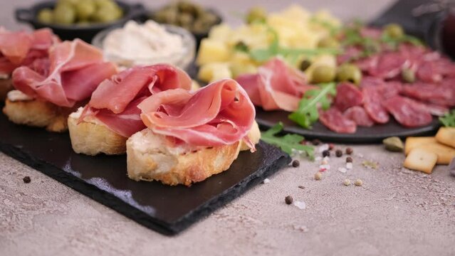 bruschetta with prosciutto or jamon ham and cream cheese on stone serving board