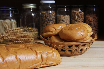 Fresh Baked Bread in Rustic Kitchen on Wooden Table With Jars of Dried Food in Background Shallow DOF
