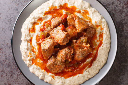 Sultan's Delight or Hunkar Begendi Lamb ragout with pureed eggplant and b&eacute;chamel sauce closeup in the plate on the table. Horizontal top view from above