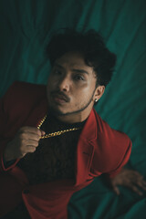 man wearing red blazer and gold chain captured from high angle. 