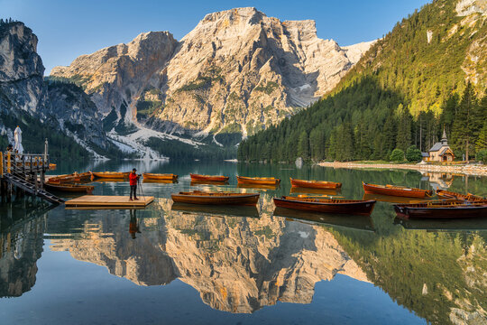 Amazing Sunrise view of Lago di Braies (Pragser Wildsee) with Wooden boats, one of the most beautiful lake in South Tirol, Dolomites mountains, Italy. Popular tourist attraction.