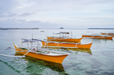 Obraz premium Beautiful tropical landscape with traditional wooden fishing boats on the sea shore.