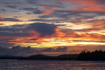 Dramatic landscape with sunset on the sea shore. Beautiful cloudy sky.