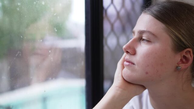 Close Up Of Sad Young Girl Gazing Out Reflective Window On Rainy Day, 4K