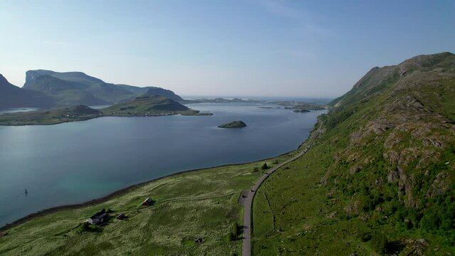 Aerial High angle tucking shot along Norwegian costal road in Lofoten during summer, drone shot.