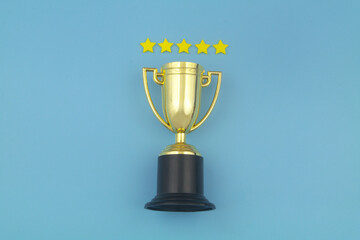 Gold champion trophy cup with five stars on blue background.