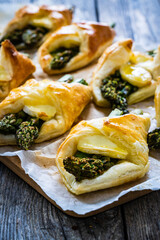 Baked puff pastry with asparagus and cheese on baking paper on wooden table - obrazy, fototapety, plakaty