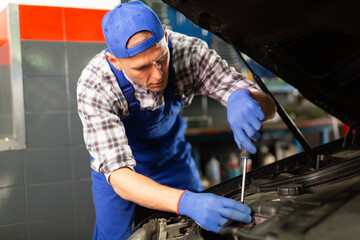 Mechanic technician working at service station, repairing car
