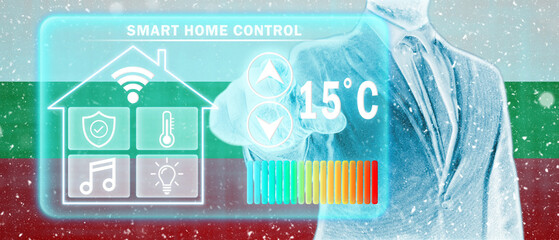 Frozen citizen of Bulgaria adjusting heating temperature on a virtual screen of smart home controller, winter blizzard. Concept of forced thrift, energy war and increased price for natural gas