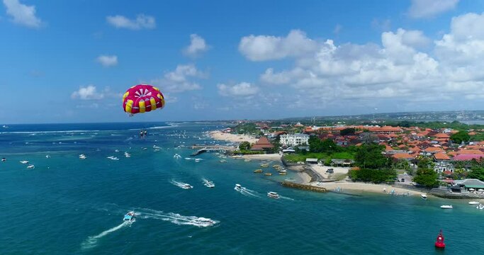 Aerial shot of a parasailing boat with 2 persons under the sail