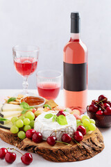 Set table with bottle of rose wine mockup, wine glasses, cheese board and fruits