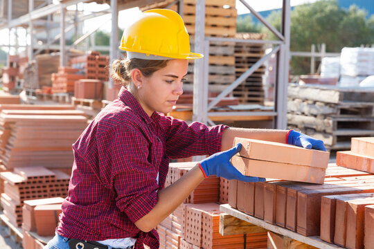 Attractive female sellerman is calculating redbricks before selling in construction store