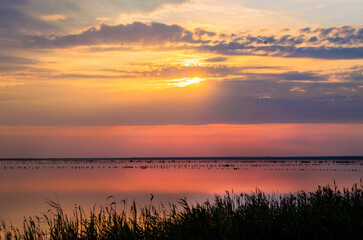 Fototapeta na wymiar Sunset on the pink lake where salt was mined before. Beautiful summer landscape