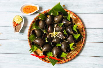 Boiled snails dipped in fish sauce close to chili.  Ingredients include snails, fish sauce, lemongrass and laksa leaves © lochuynh