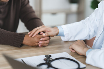 Obraz na płótnie Canvas Doctor or psychiatrist shakes hands encouragement the patient and care having a consultation on diagnostic examination on male disease or mental illness in a clinic or hospital mental health service