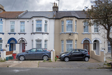 Fototapeta na wymiar Essex. England. UK, Great Brittain. Common British houses and two parked cars.