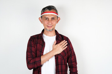 Portrait of Asian Man wearing red and white Indonesia flag attribute. Independence day concept.
