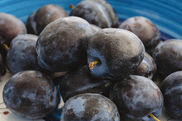close-up view of fresh ripe sugar plums in pottery bowl