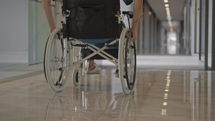 Female patient in wheelchair in hospital hallway,Low angle view,