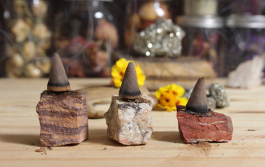 Incense Cones and Chakra Stones With Flowers in Background Shallow DOF