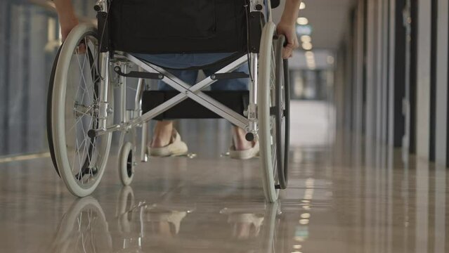Female patient in wheelchair in hospital hallway,Low angle view,Slow motion