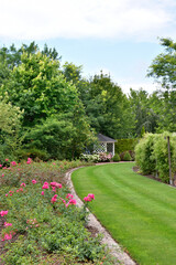 A show garden with grasses, a lake and various decorations in Poland.