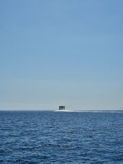 Fototapeta premium Rear view of a ship at sea on the horizon, Spain