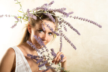 Sommermotiv, Frau hält russischen Lavendel in den Händen und trägt einen Zweig mit Blüten auf dem Kopf.