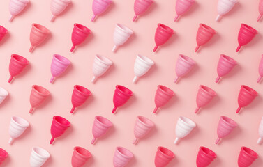 Pattern of colorful menstrual cups on a pink background for banner design in flat lay. Zero waste, eco and reusable alternatives for period and woman hygiene concept in 3D illustration