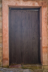 old wooden entrance door in a stone wall in a medieval village