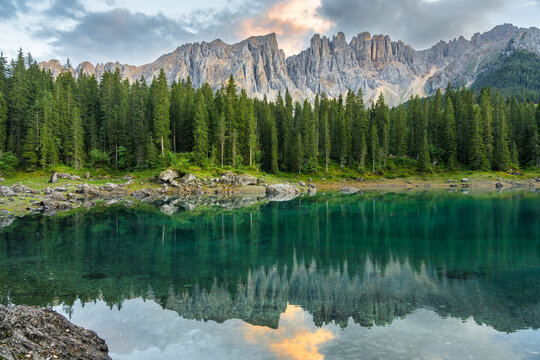 Italian alps. Silent morning on the lake of Carezza surrounded by pine forest and mountains.