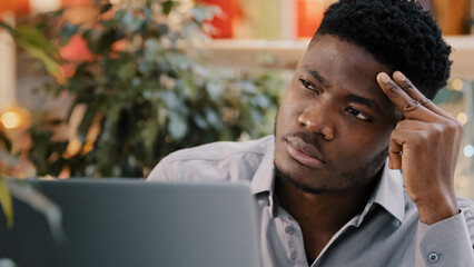 Close-up young male businessman looking at laptop screen receiving email reading shocking bad news...