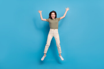 Full size photo of funky young brunette lady jump wear casual cloth isolated on blue background